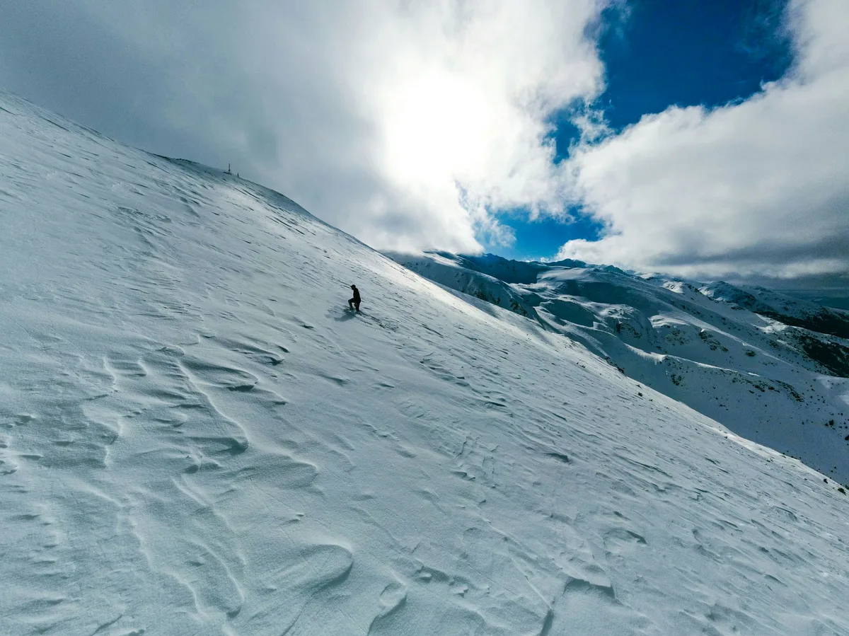 A skier descending a snow-covered slope in the mountains near Brezovica, Kosovo