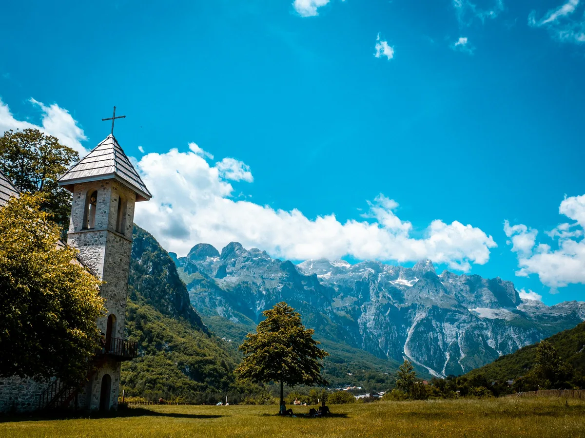 A stone church beneath the dramatic peaks of the Albanian Alps