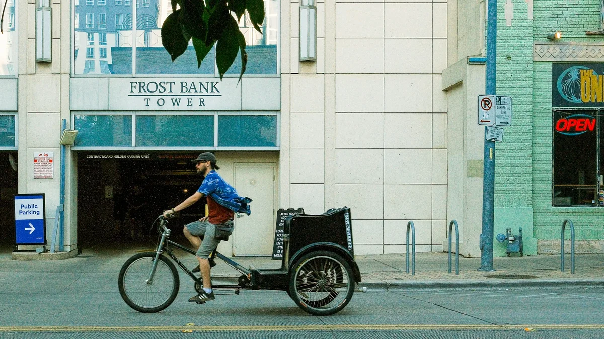 A pedicab rider pedaling through a lively downtown street