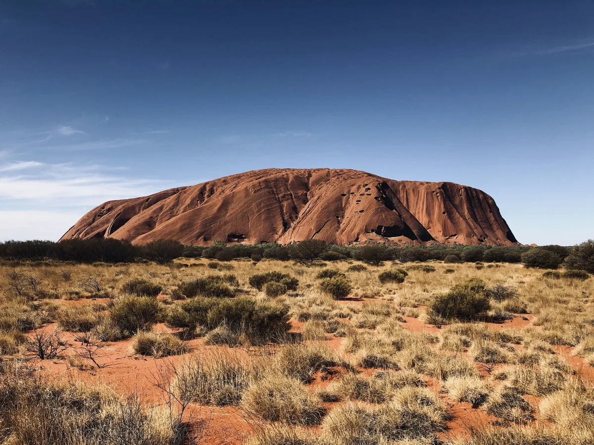 Uluru rising above the red desert scrub of Australia's Red Centre