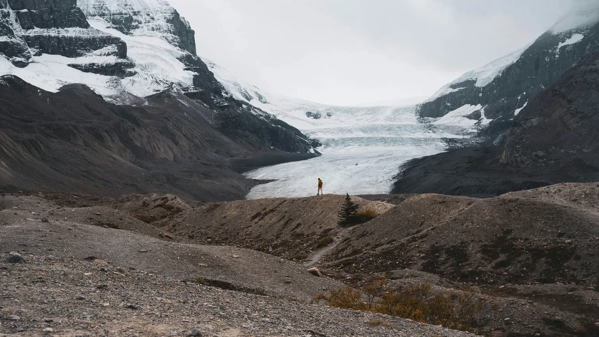 The Athabasca Glacier flowing between snow-capped peaks at the Columbia Icefield