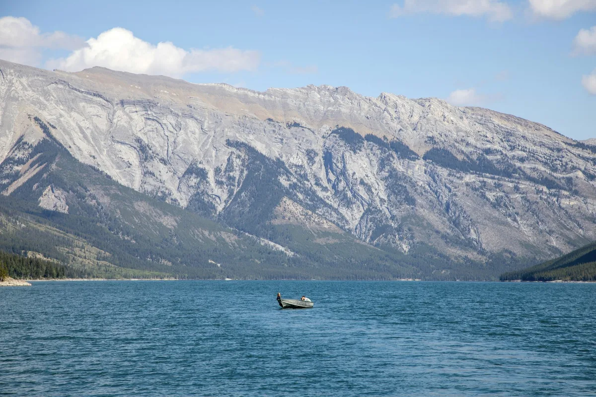 A small boat on the turquoise waters of Lake Minnewanka in Banff National Park