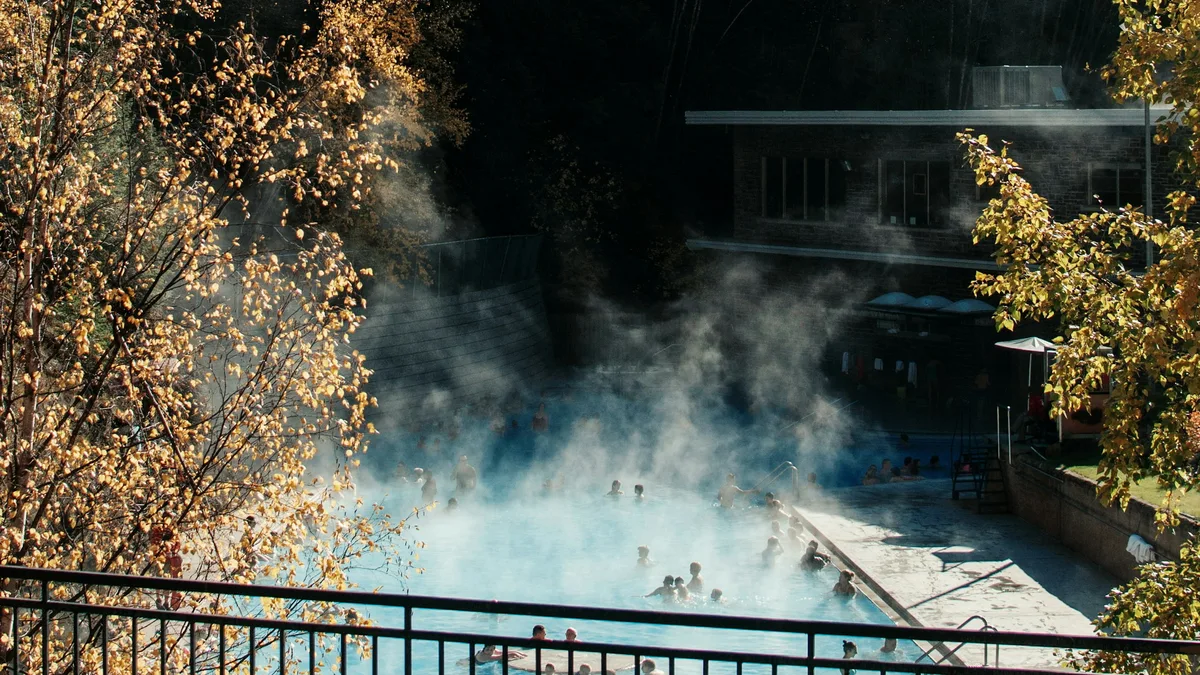 Steam rising off the outdoor pools at Radium Hot Springs, surrounded by forested mountains