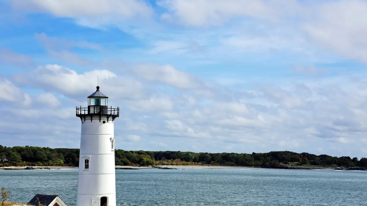 A white lighthouse on a rocky coastal point