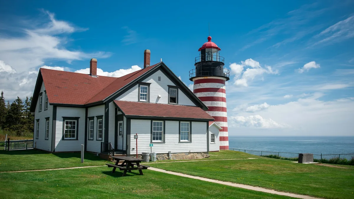 A red and white striped lighthouse on a remote coastal headland