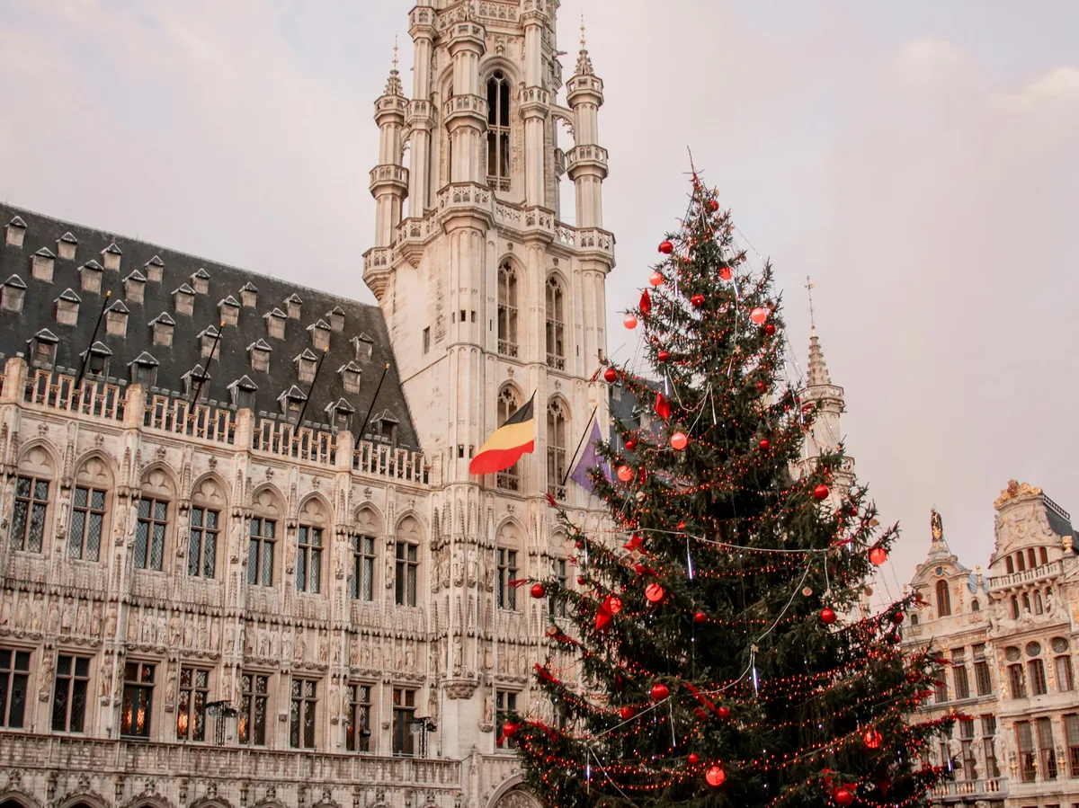 A Christmas market with festive lights in a Belgian city square