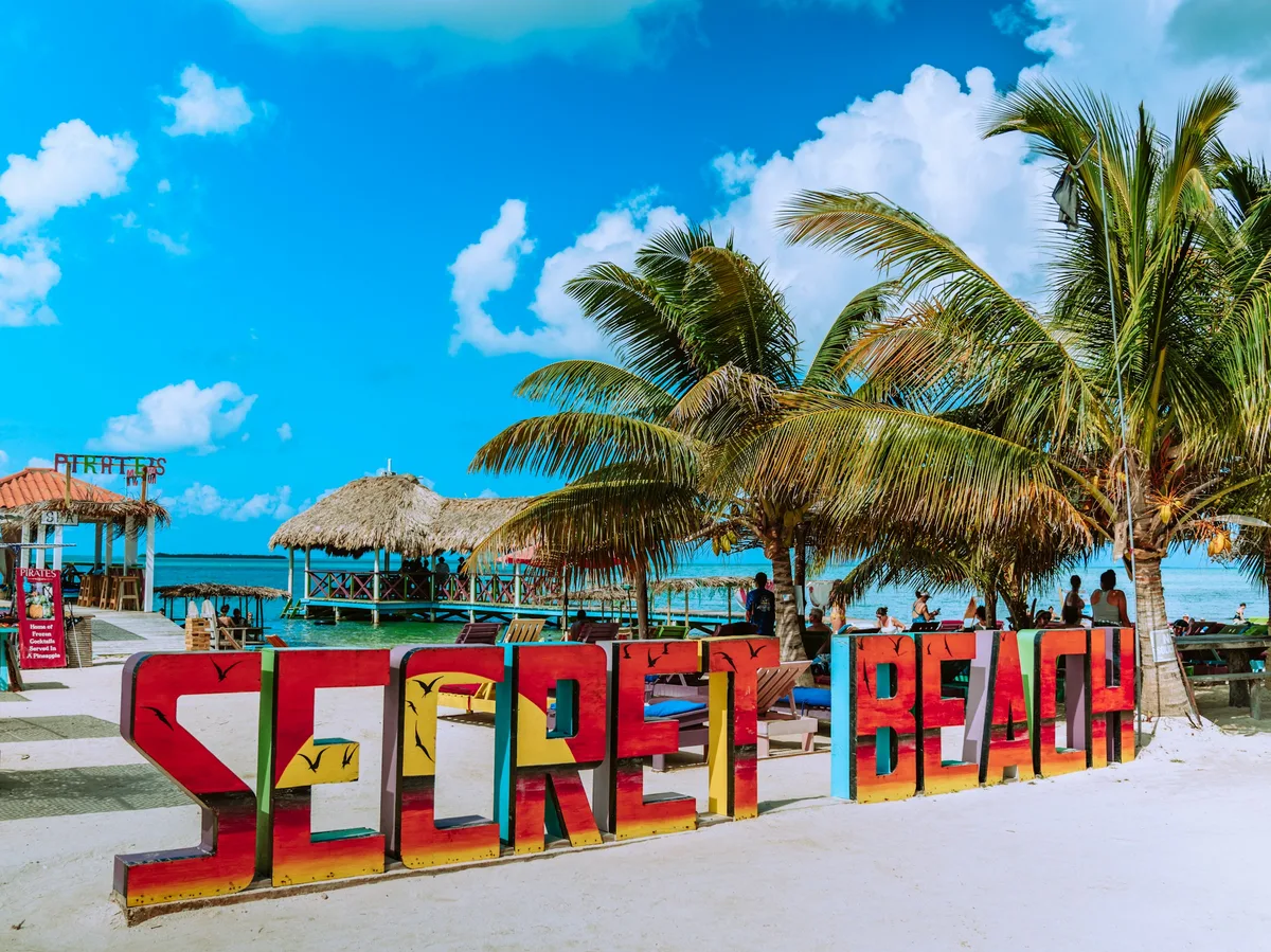Palm trees along a white sand Caribbean beach in Belize