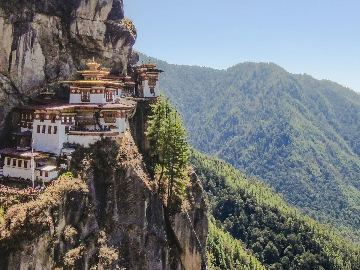 A white and brown monastery building on a Bhutanese hilltop