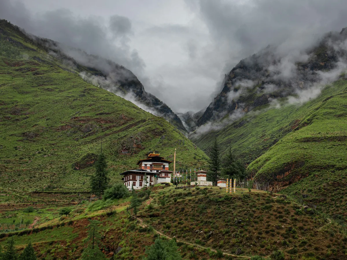 A traditional house set amid a dramatic Himalayan mountain range