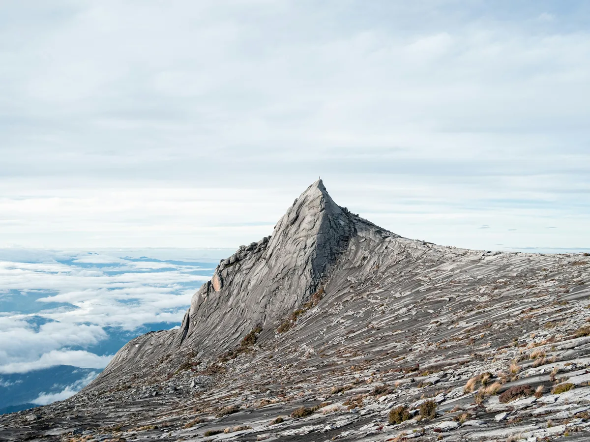Mount Kinabalu's jagged granite peak rising above the rainforest in Sabah, Malaysia