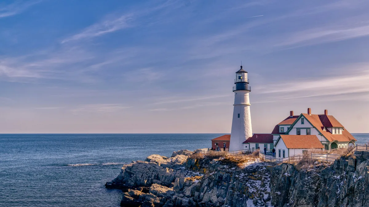 A lighthouse overlooking a rocky New England shoreline