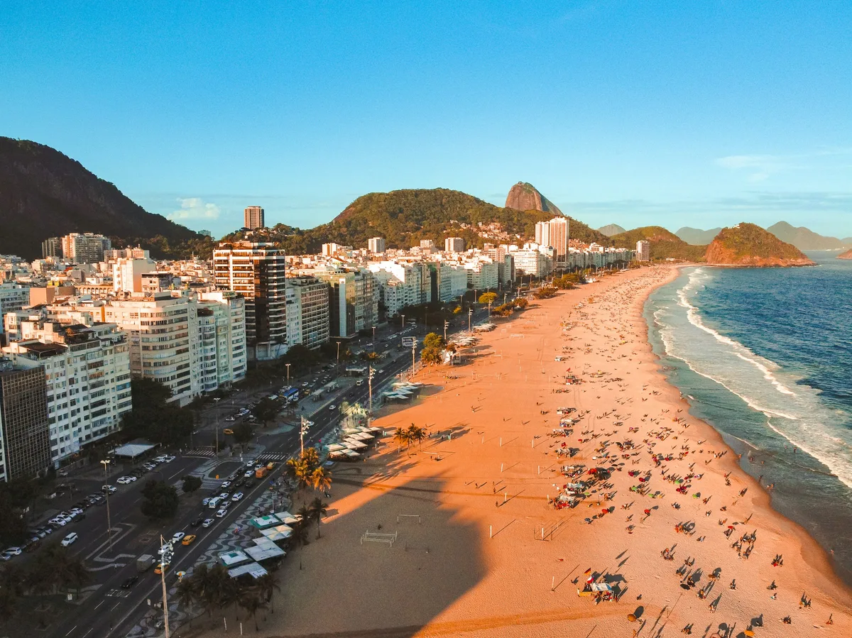 Aerial view of a Rio de Janeiro beach lined with the city's mountains