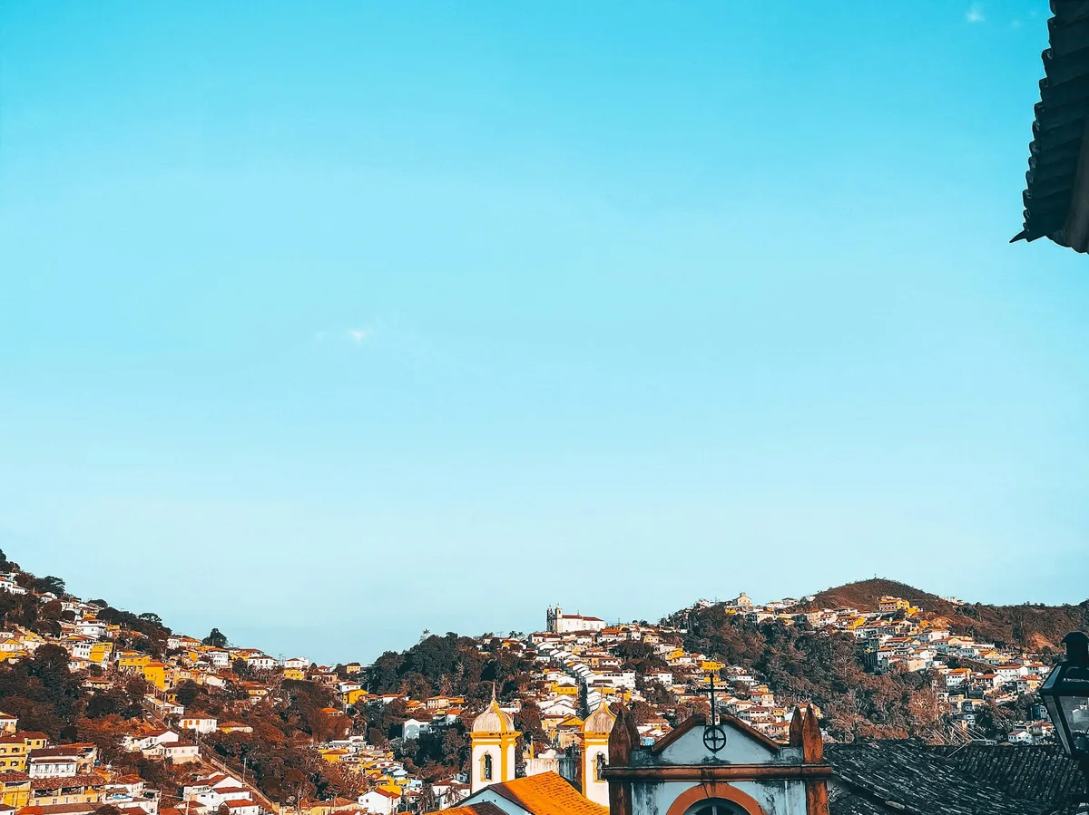A small colonial church on a hill overlooking a Minas Gerais town