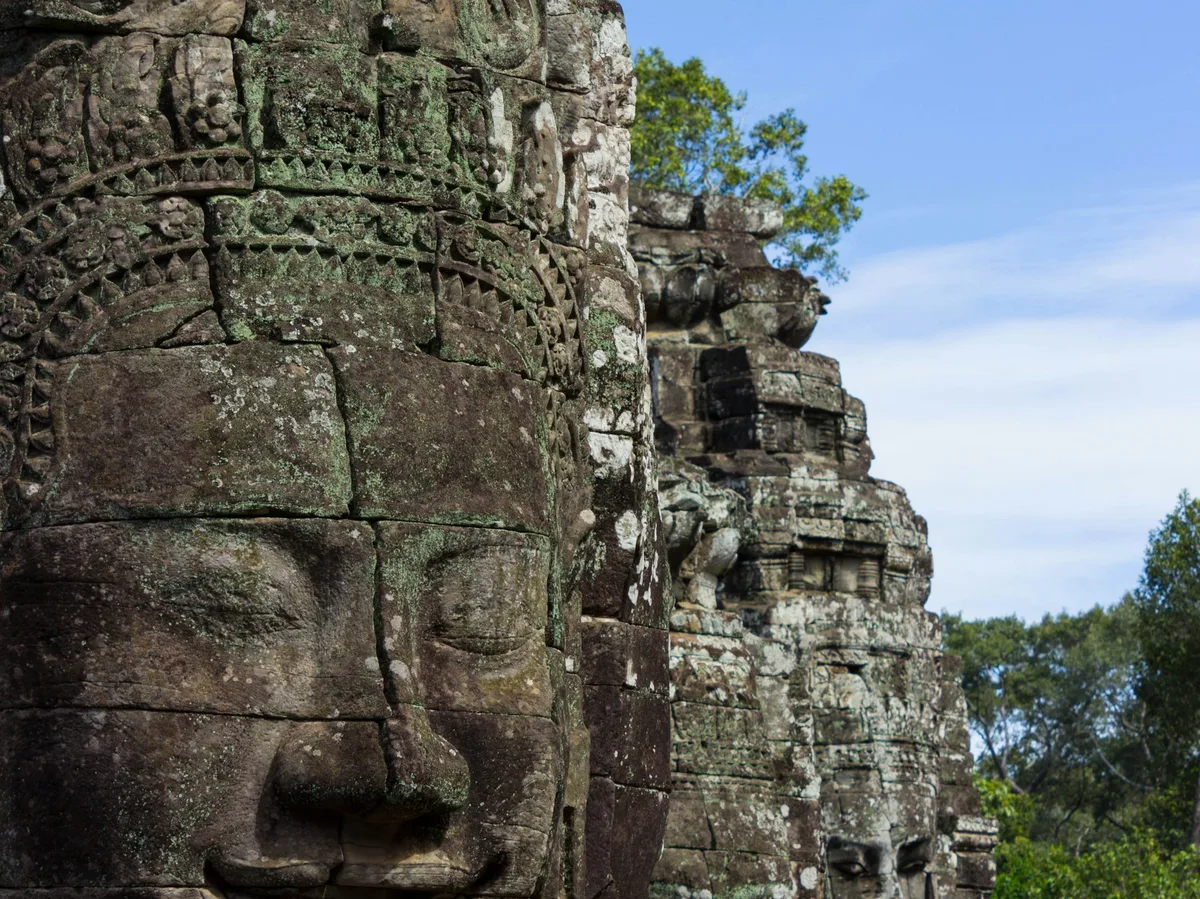 Weathered stone face carving at the Bayon temple within Angkor Thom, Cambodia