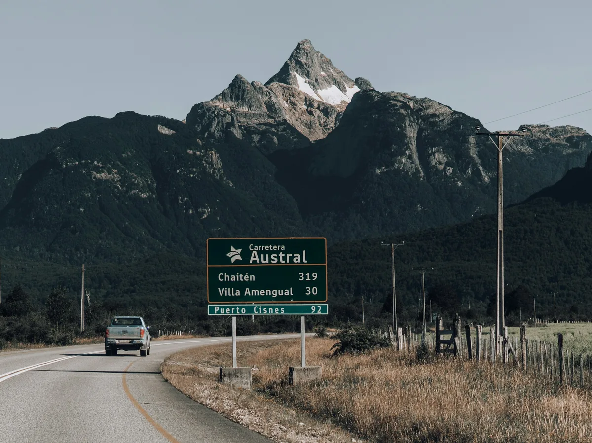 The gravel Carretera Austral highway winding through forested mountains in Chilean Patagonia
