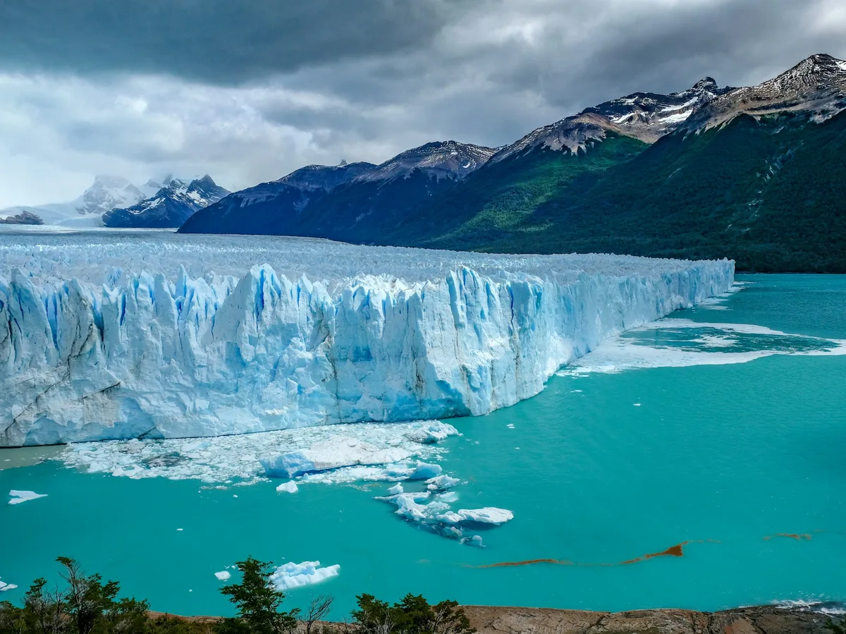 Hikers on a trail with the granite towers of Torres del Paine rising behind them
