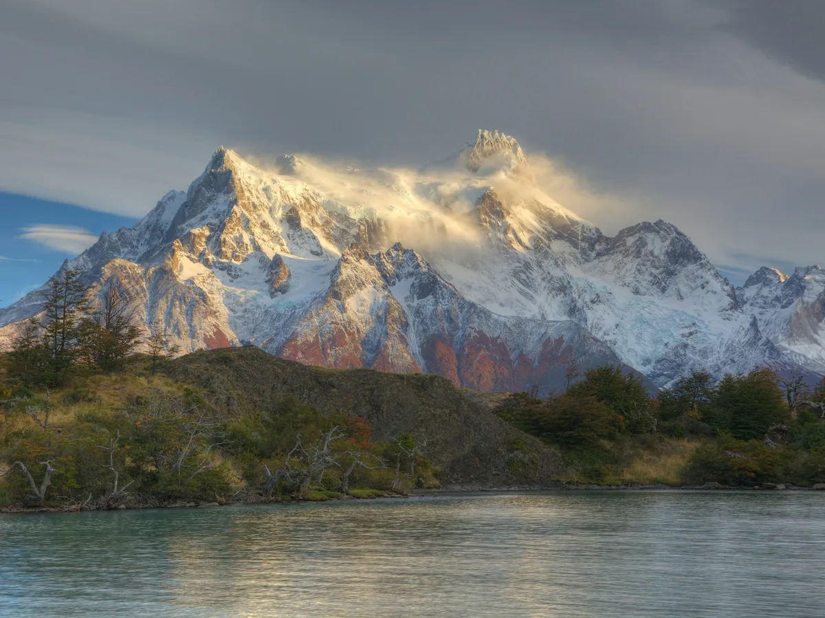Hikers on a trail overlooking Lake Pehoé in Torres del Paine National Park, Chile
