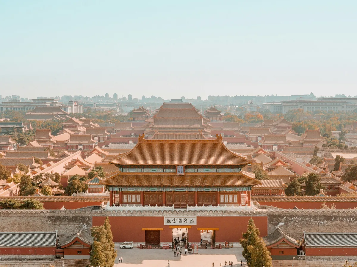 The red walls and golden roofs of Beijing's Forbidden City under a clear sky
