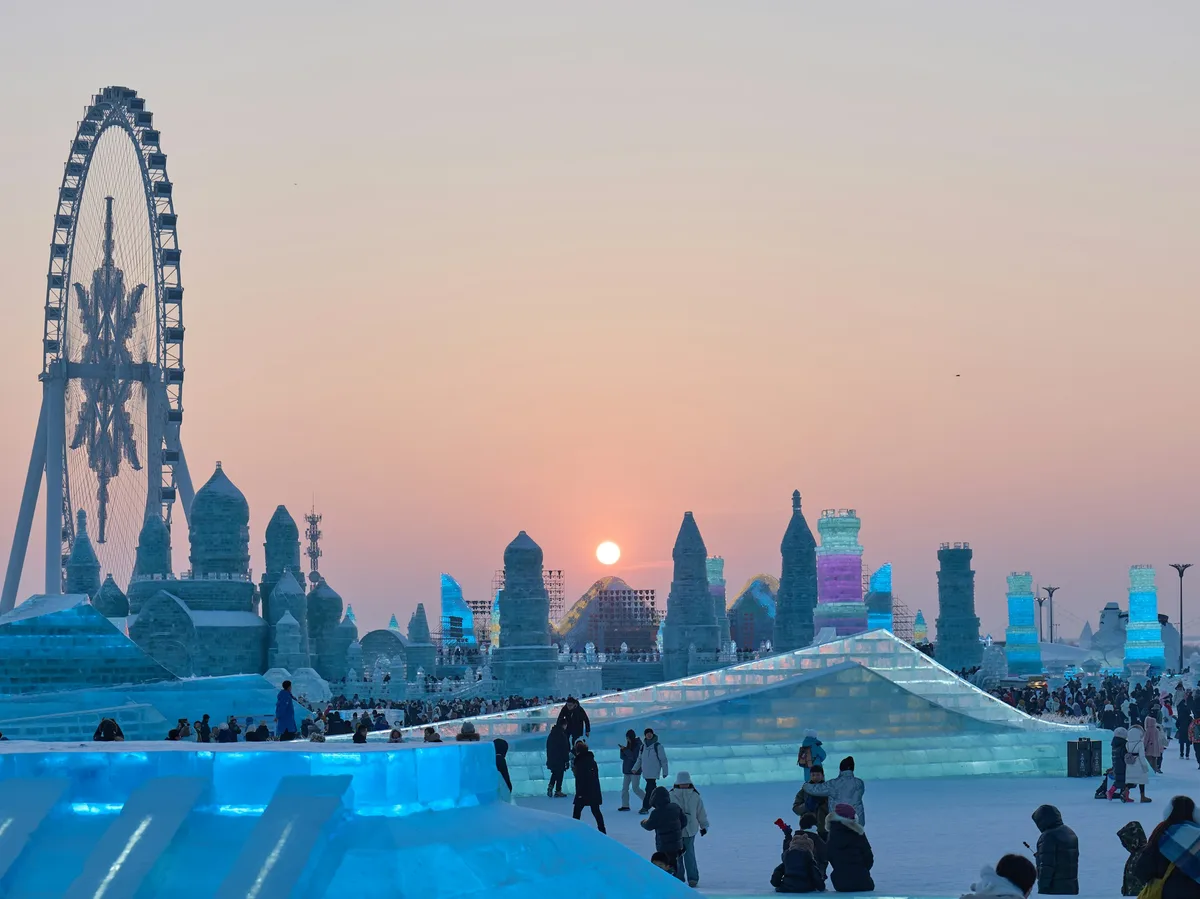 Visitors gathered around illuminated ice sculptures at Harbin's Ice and Snow World