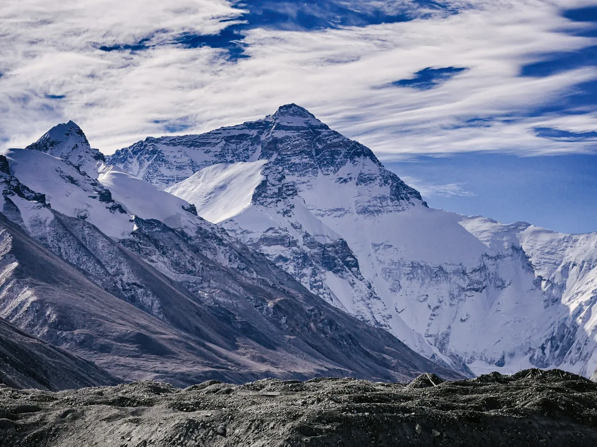 Snow-covered Himalayan peaks under a clear blue sky, seen from the Tibetan plateau