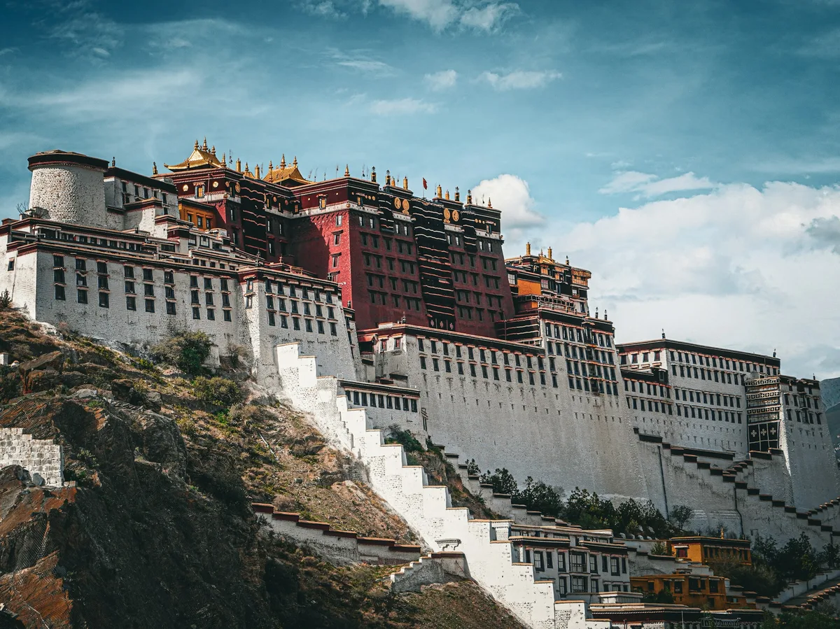 The Potala Palace towering above Lhasa, Tibet, against a mountain backdrop
