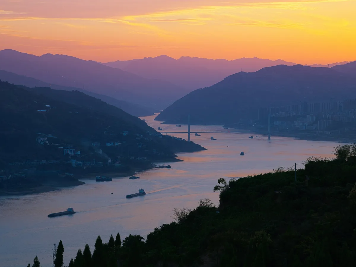 A sunset view over the Yangtze River with mountains in the background