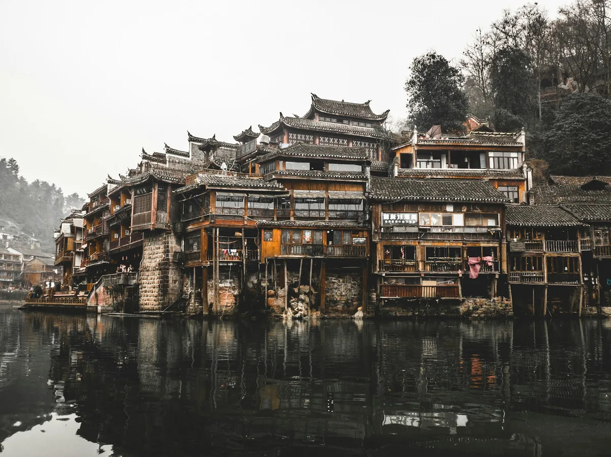 Traditional wooden houses beside a river in a Yunnan mountain village