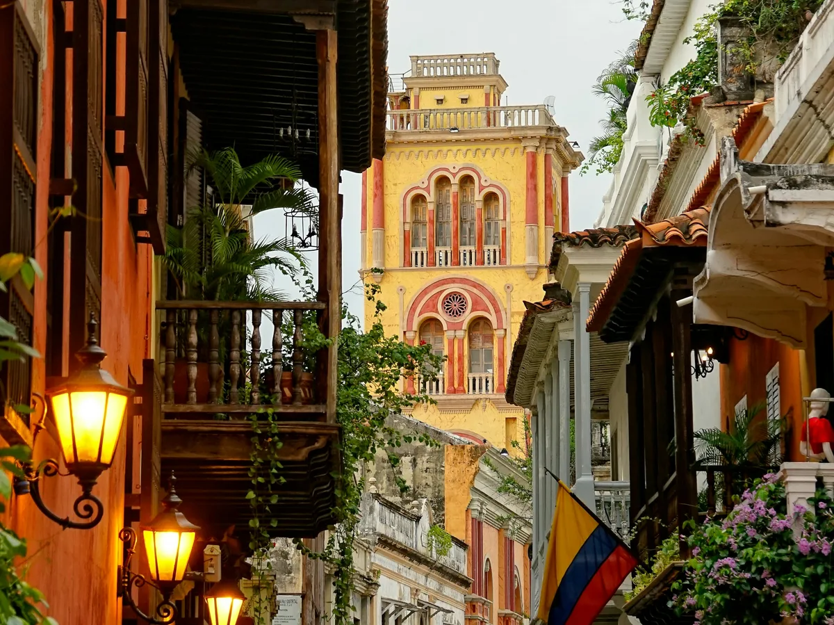 A narrow colonial street in Cartagena lined with balconied buildings
