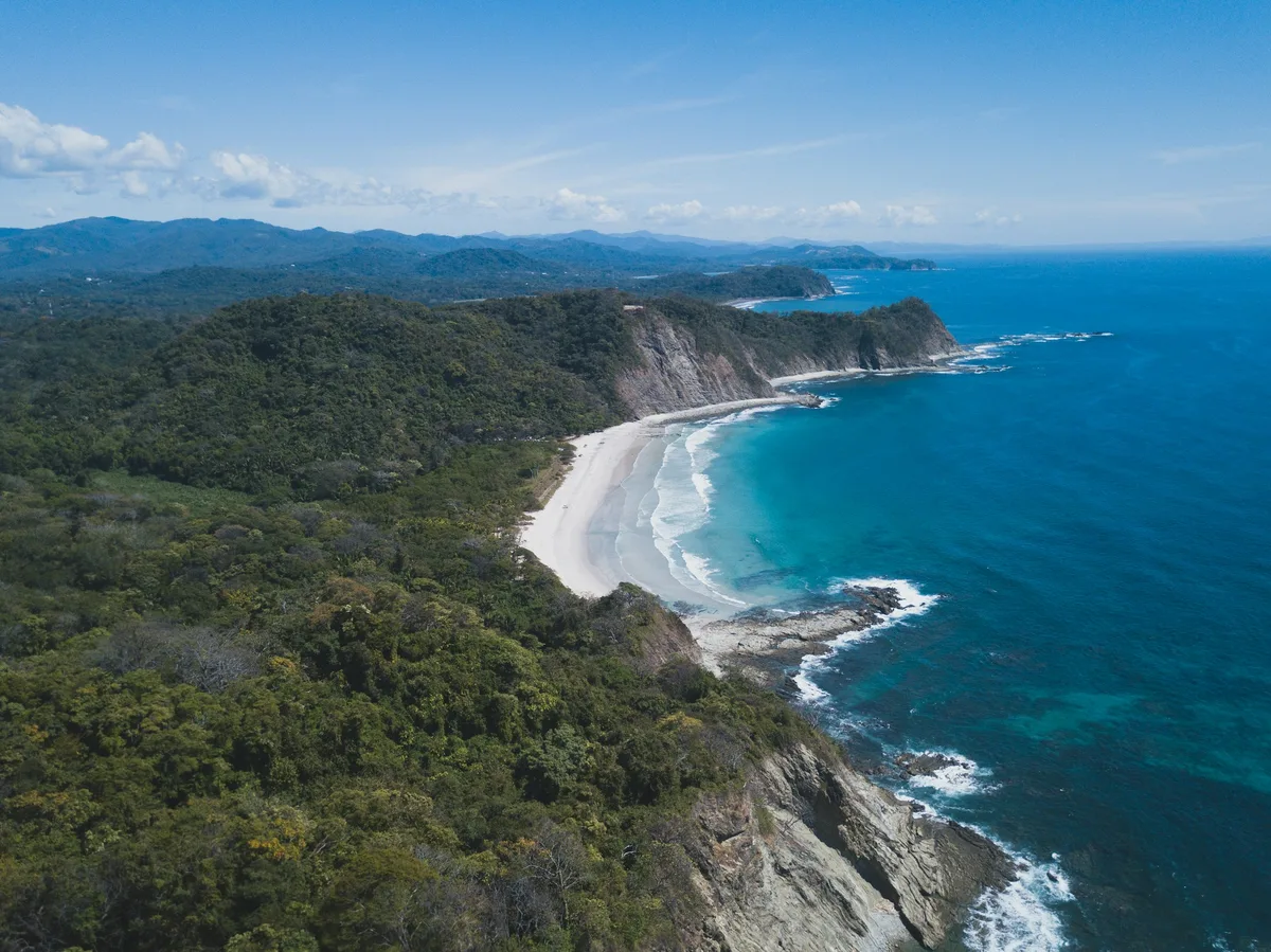 An aerial view of a pristine beach meeting the Pacific along Costa Rica's Guanacaste coast