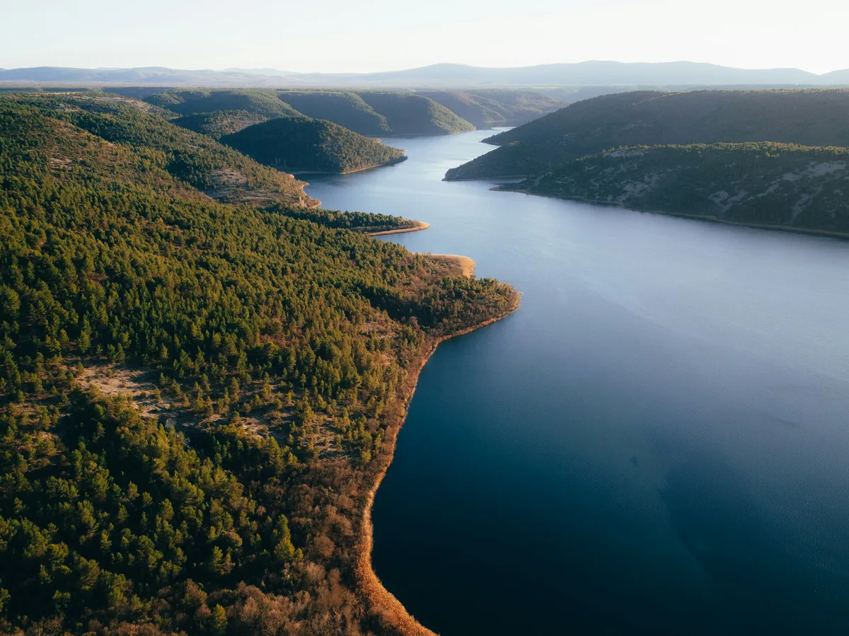 A calm river winding through green forested countryside in inland Croatia