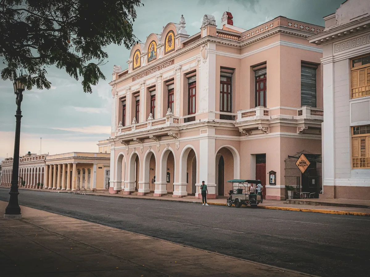 The pastel-pink facade of the historic Tomás Terry Theatre on a quiet street in Cienfuegos, Cuba