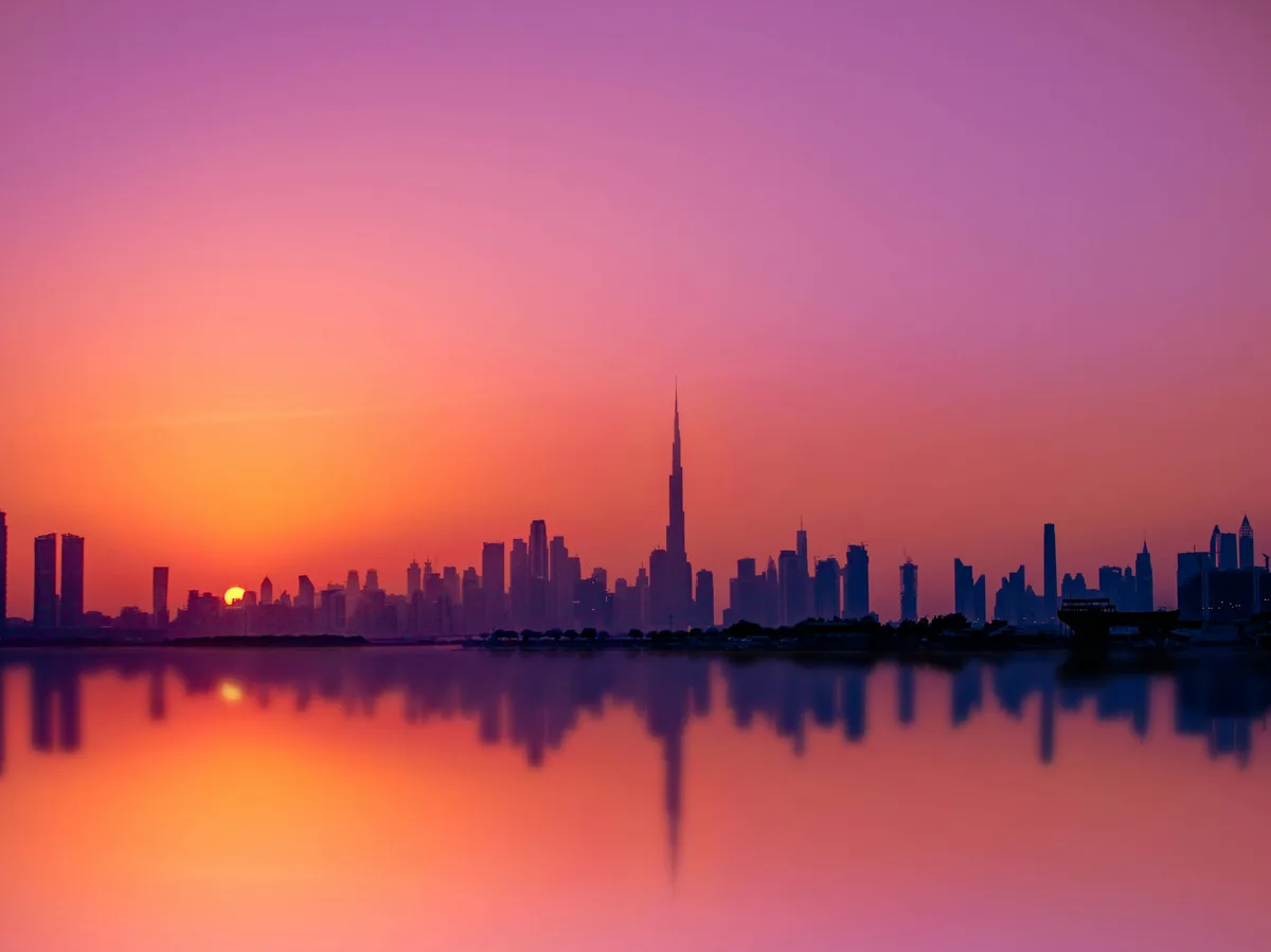 Dubai skyline silhouetted at sunset from the beach