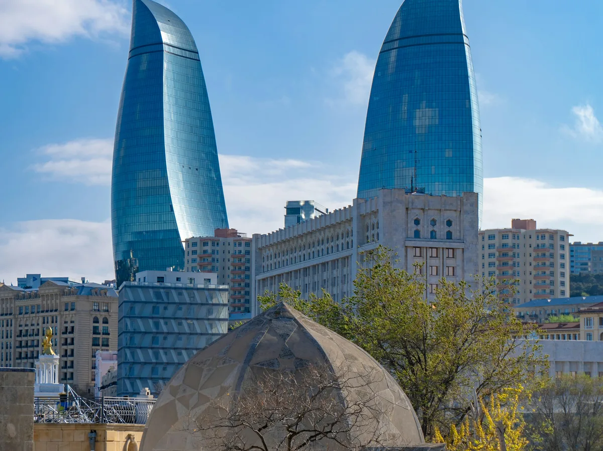 Baku's Flame Towers rising behind the city's old stone buildings, Azerbaijan