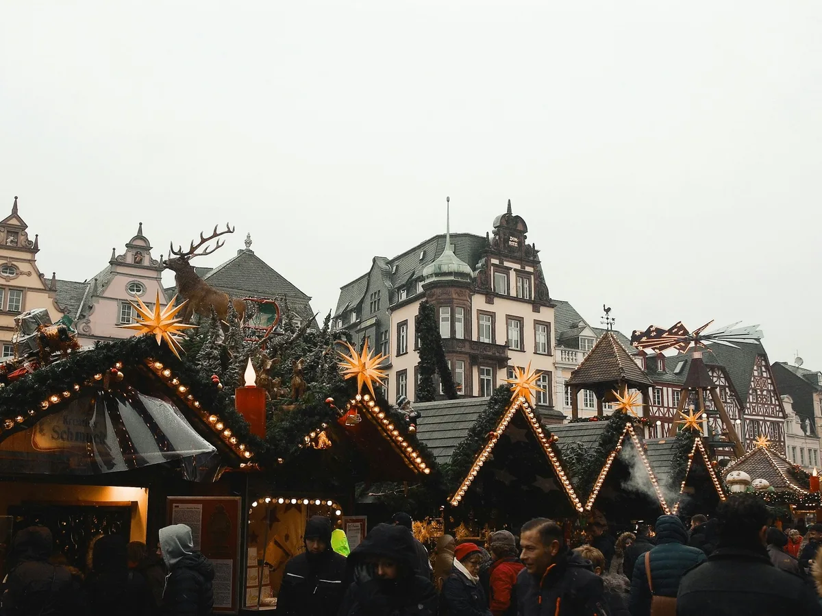Traditional wooden Christmas market stalls strung with lights in a German old town