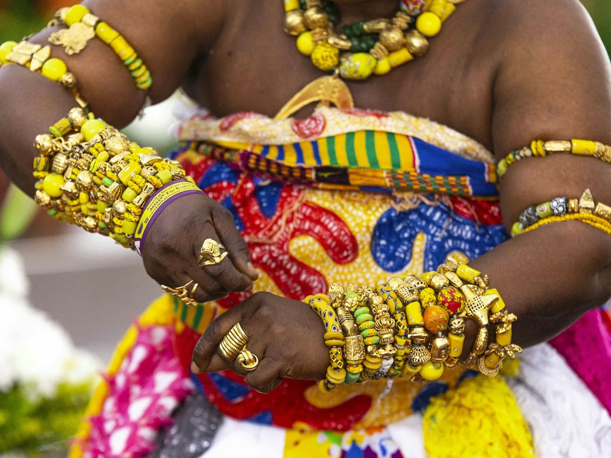 A woman in traditional colorful West African dress and jewelry