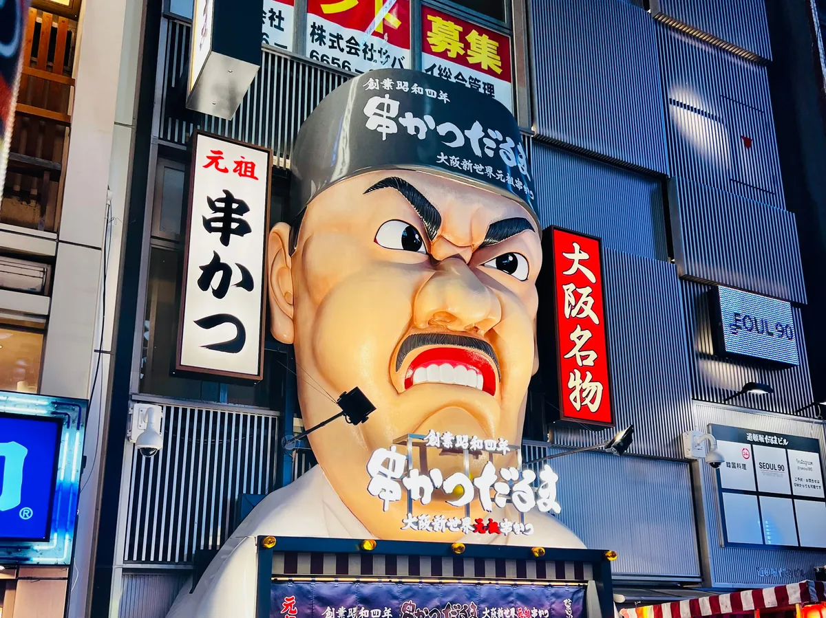 The Glico Running Man sign lit up above the Dotonbori canal in Osaka, Japan