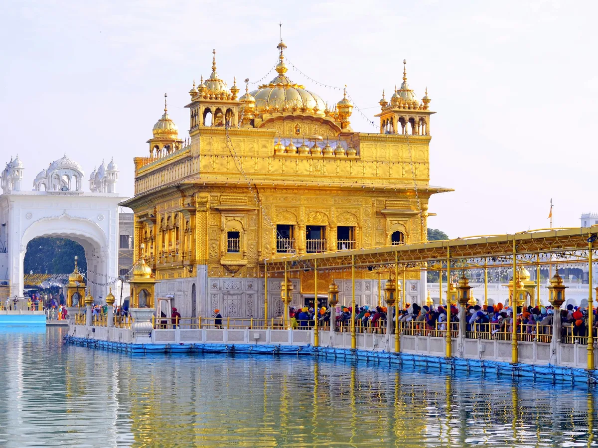 The Golden Temple in Amritsar with pilgrims on the walkway over water
