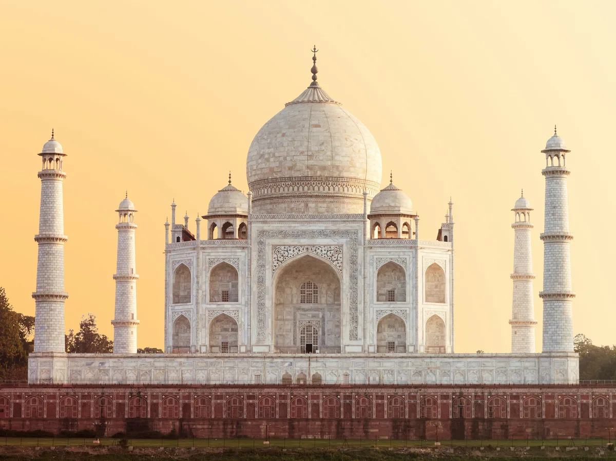 The Taj Mahal in Agra under a warm golden hour sky