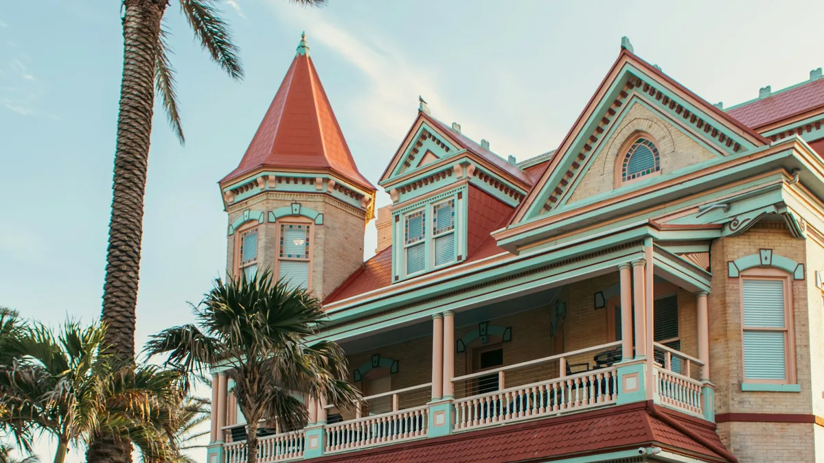 A colorful Victorian mansion with palm trees in Key West