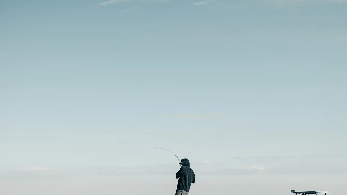 An angler on a flats fishing boat casting a line