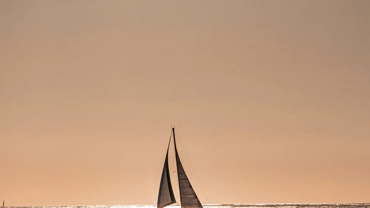 A sailboat on calm water at sunset