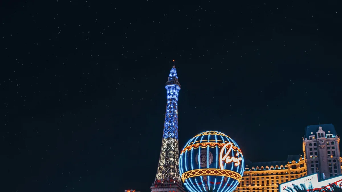 The Las Vegas Strip lit up at night, with the Eiffel Tower Paris Las Vegas replica and light trails from passing traffic