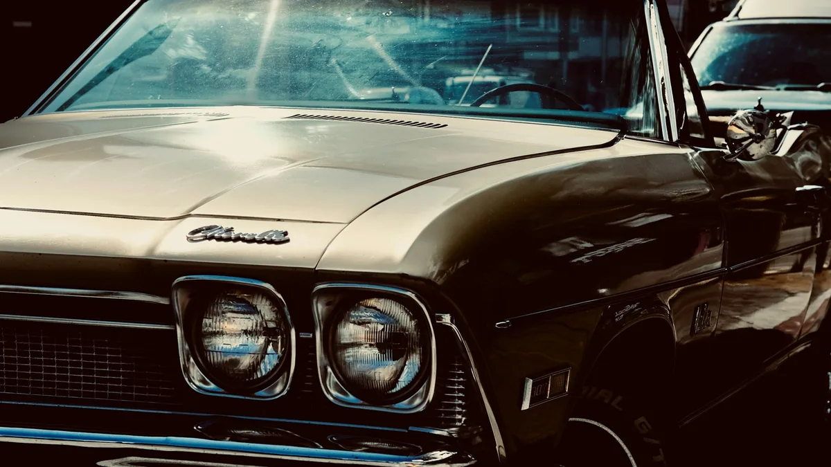 A classic 1960s American convertible car parked at dusk