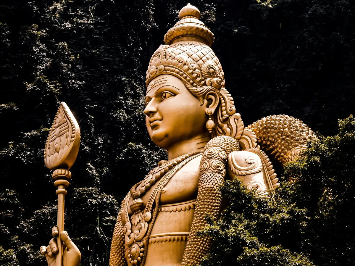 A golden statue and colorful steps at the entrance to Batu Caves, Kuala Lumpur, Malaysia