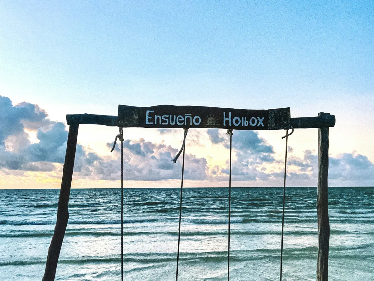 A wooden swing over the Caribbean Sea on Holbox Island, Mexico