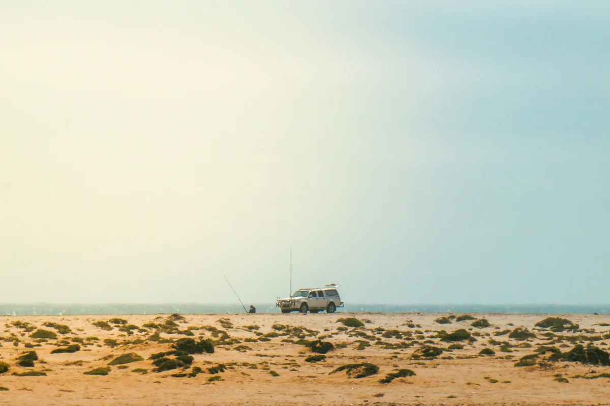 A 4x4 vehicle on the desert coastline where the Namib Desert meets the Atlantic Ocean, Namibia