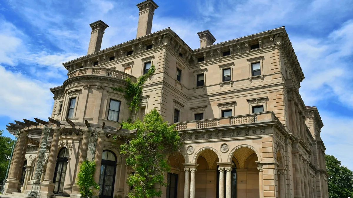 A grand Gilded Age mansion with manicured lawns overlooking the ocean
