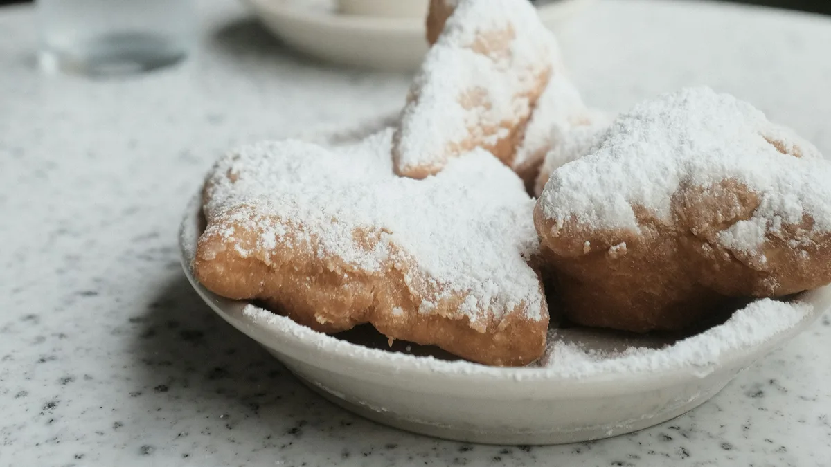 Fried dough pastries dusted with powdered sugar on a plate