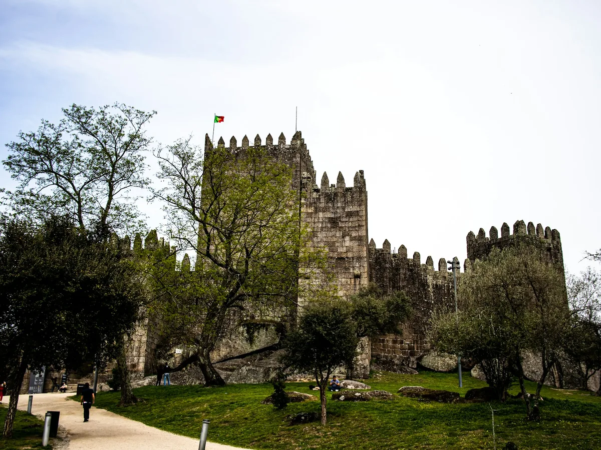 Guimarães Castle among trees and grass, Portugal