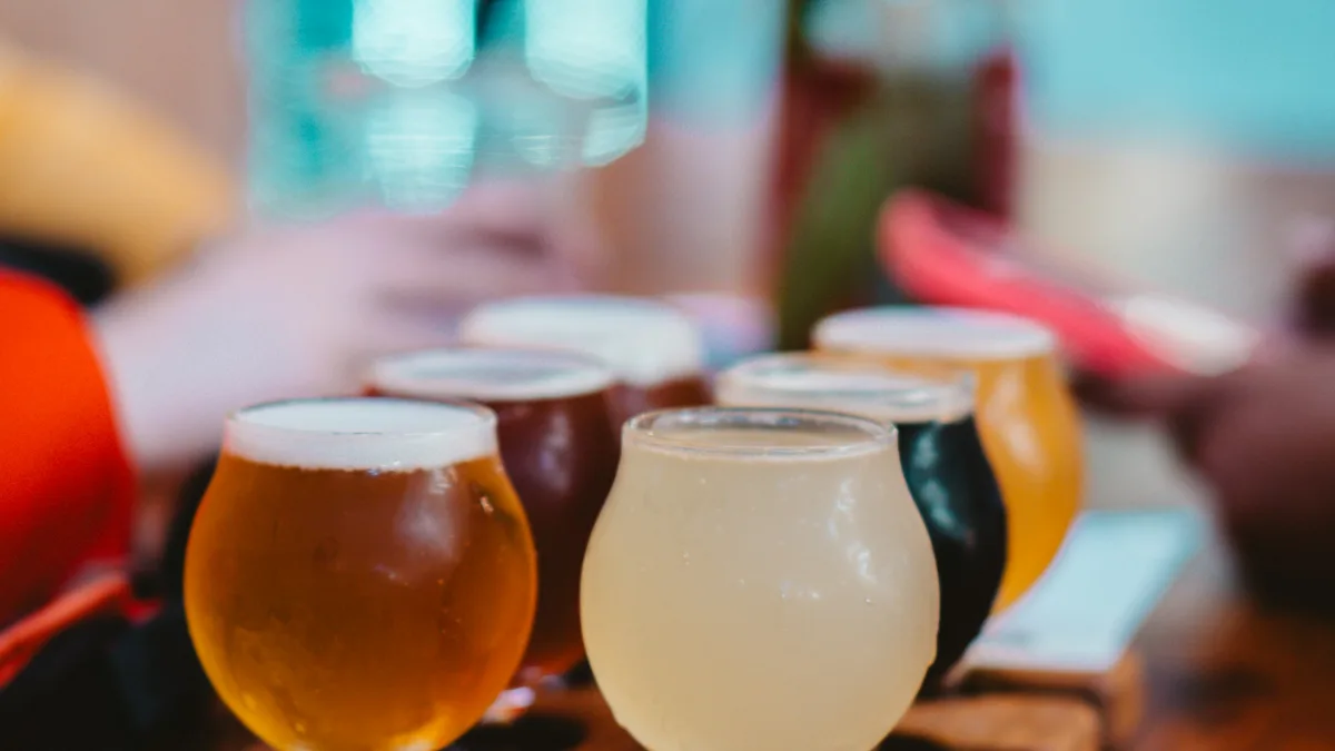 Flights of craft beer samples lined up on a wooden bar